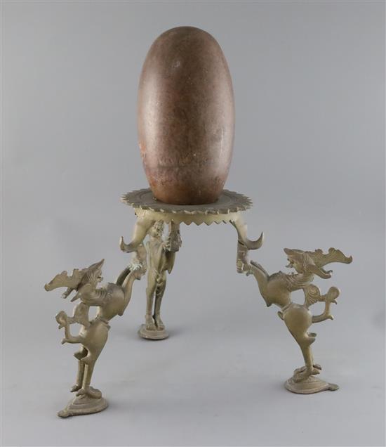 An Indian Lingham stone with 19th century bronze tripod stand, overall H.18in.